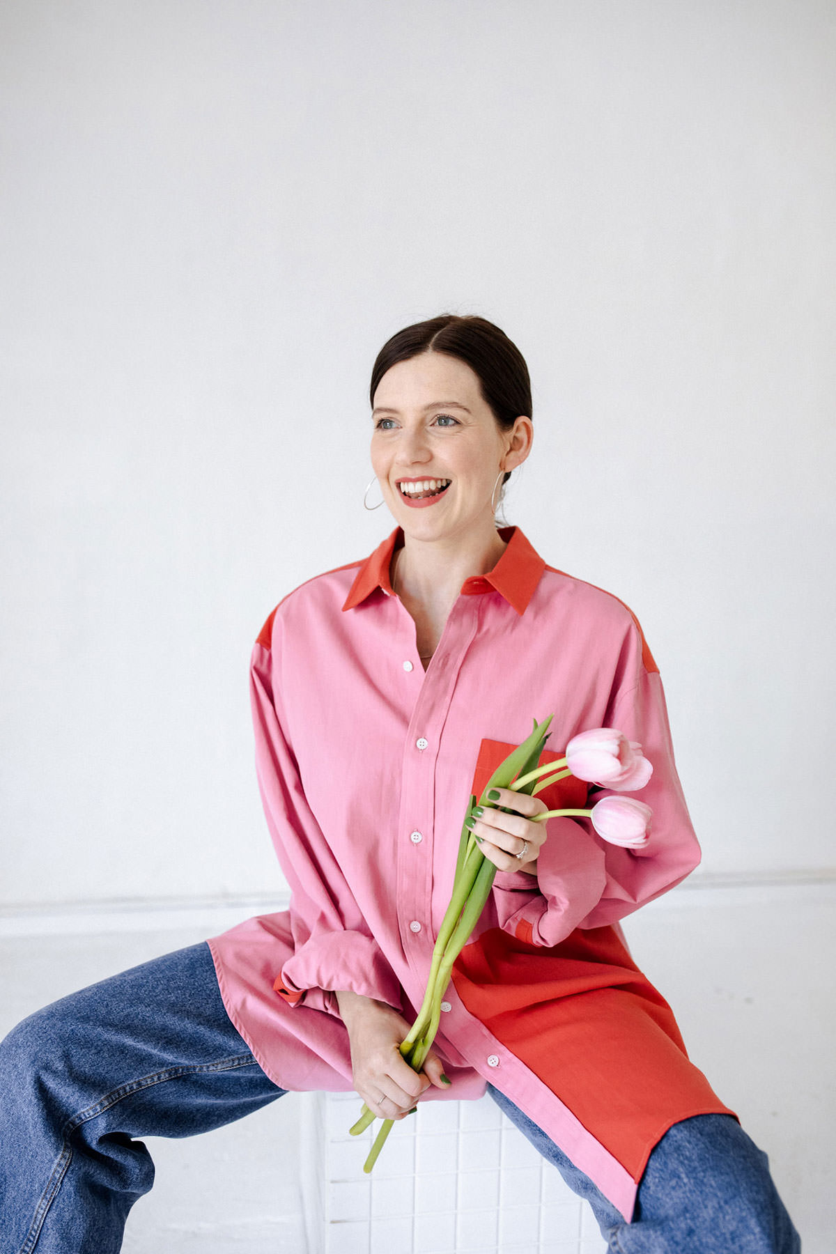 amy pearson smiling holding flowers pink shirt
